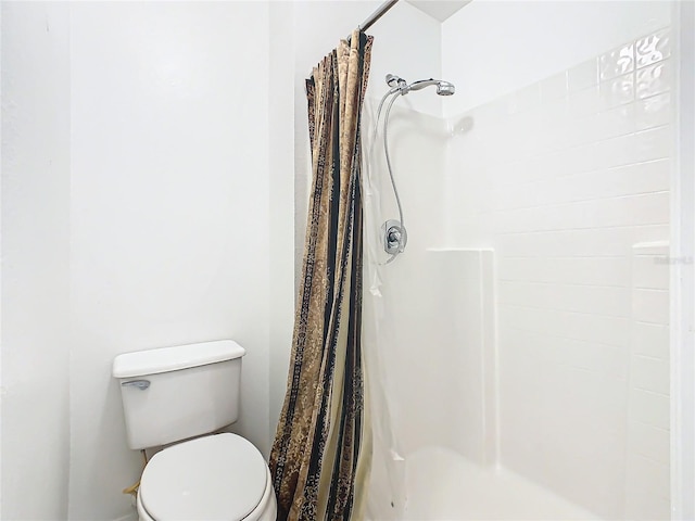 bathroom featuring a shower with curtain and toilet