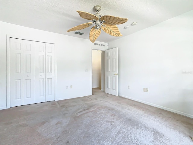 unfurnished bedroom with a textured ceiling, ceiling fan, and a closet