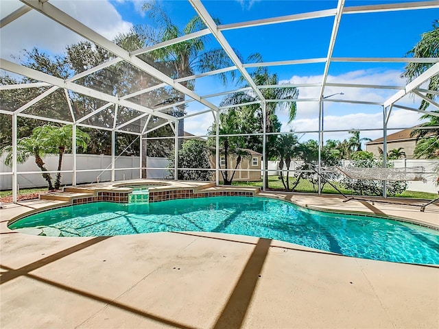 view of swimming pool with an in ground hot tub, a storage unit, a lanai, and a patio area