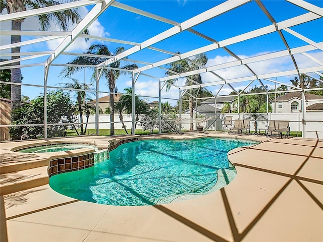 view of swimming pool with an in ground hot tub, a patio, and glass enclosure