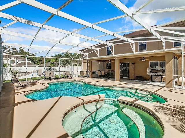 view of pool with a lanai, a patio, ceiling fan, and an in ground hot tub