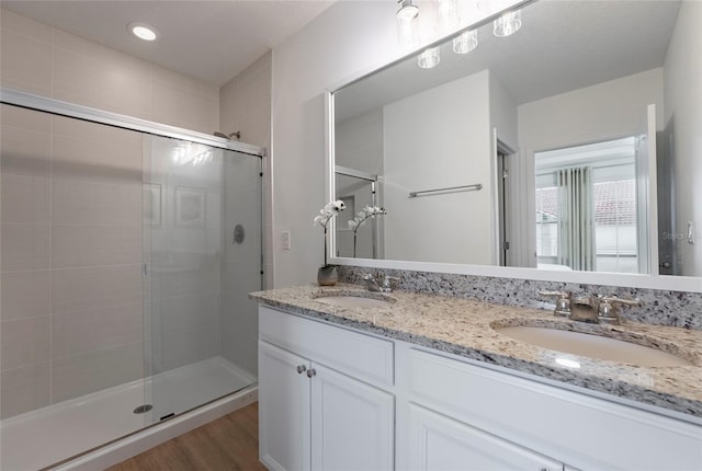 bathroom featuring vanity, hardwood / wood-style floors, and a shower with shower door