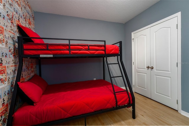 bedroom featuring a closet, a textured ceiling, and wood-type flooring