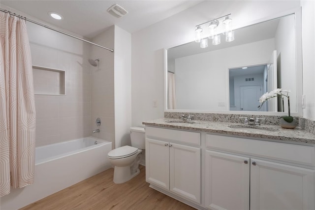 full bathroom featuring toilet, vanity, wood-type flooring, and shower / tub combo