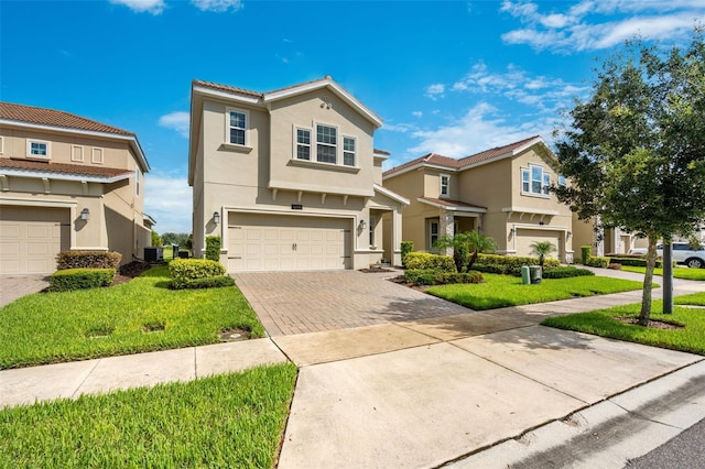 view of front of house with a garage, a front lawn, and central AC unit