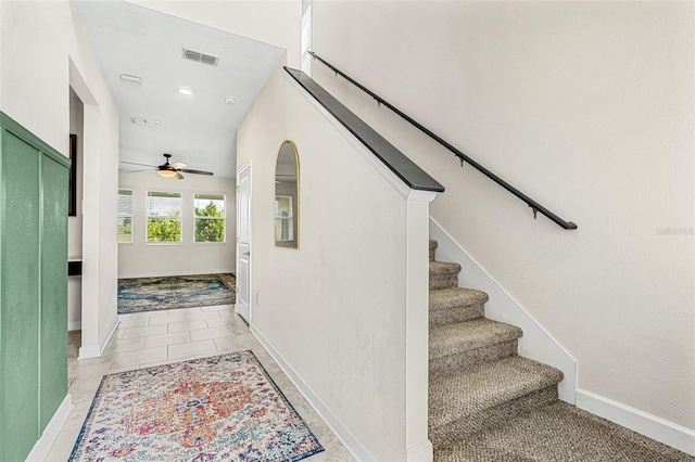 staircase with tile patterned floors and ceiling fan