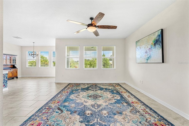 tiled living room featuring ceiling fan with notable chandelier