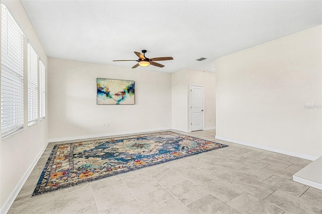 unfurnished room with a textured ceiling and ceiling fan