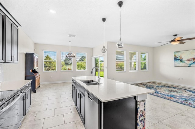 kitchen with a center island with sink, sink, decorative light fixtures, and a healthy amount of sunlight