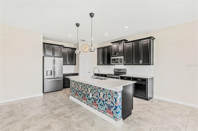 kitchen with sink, stainless steel appliances, decorative light fixtures, decorative backsplash, and a kitchen island with sink