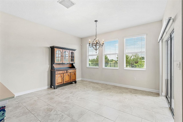 tiled dining area featuring an inviting chandelier and a textured ceiling