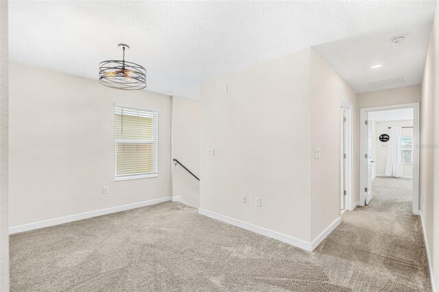 carpeted spare room featuring a textured ceiling