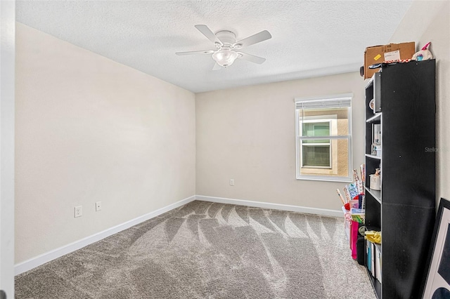 recreation room with carpet floors, a textured ceiling, and ceiling fan