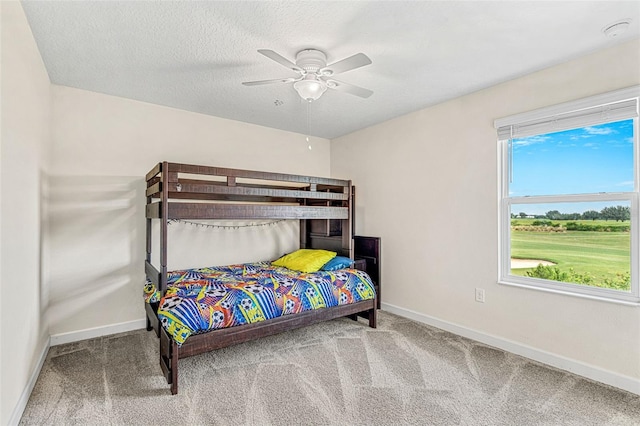 bedroom featuring carpet flooring, a textured ceiling, and ceiling fan