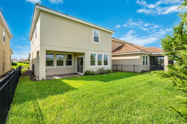 back of property with a patio and a lawn