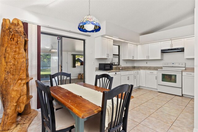 1402 Westminster Way, Kissimmee, FL 34744 - kitchen featuring white appliances, under cabinet range hood, light tile patterned flooring, white cabinets, and vaulted ceiling