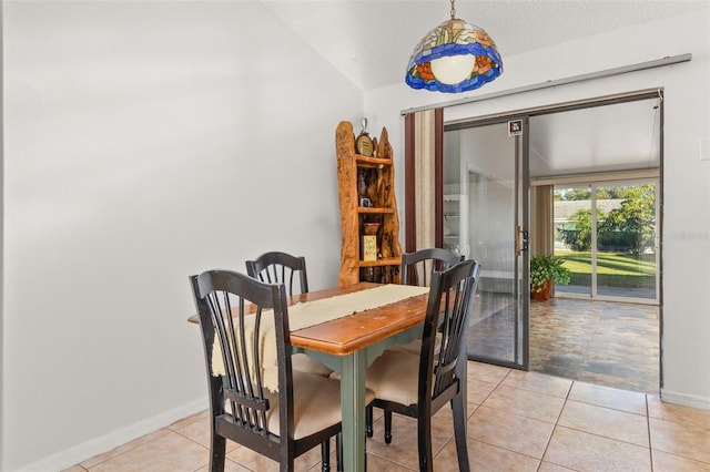 1402 Westminster Way, Kissimmee, FL 34744 - dining room featuring light tile patterned floors, baseboards, a textured ceiling, and vaulted ceiling