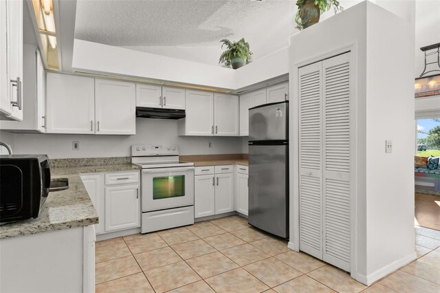1402 Westminster Way, Kissimmee, FL 34744 - kitchen featuring white electric range, freestanding refrigerator, under cabinet range hood, light tile patterned floors, and white cabinetry