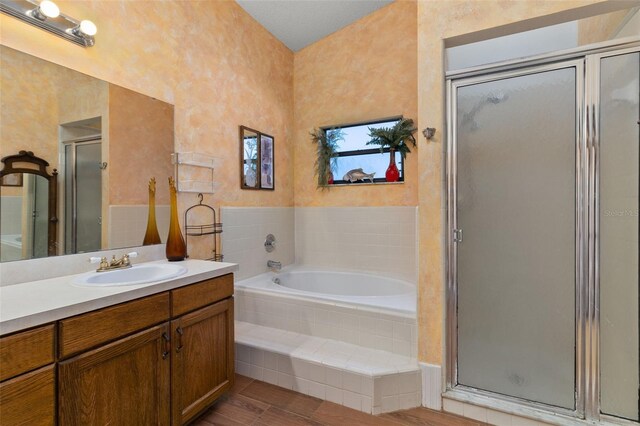1402 Westminster Way, Kissimmee, FL 34744 - bathroom featuring vanity, a shower stall, a garden tub, and wood finished floors