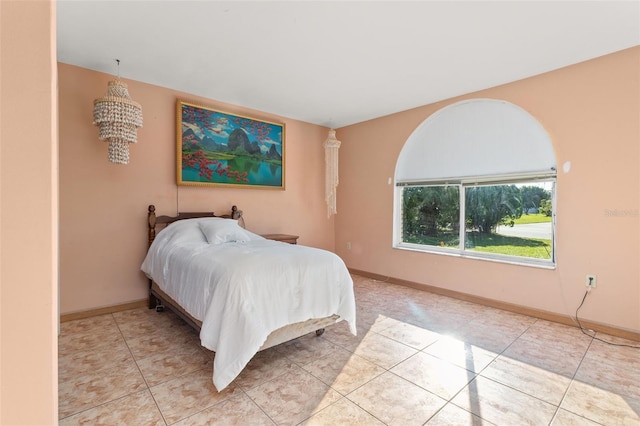 bedroom featuring an inviting chandelier and light tile patterned floors