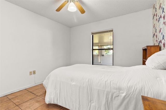 tiled bedroom featuring a textured ceiling and ceiling fan