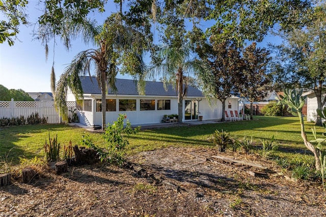 rear view of property featuring a lawn