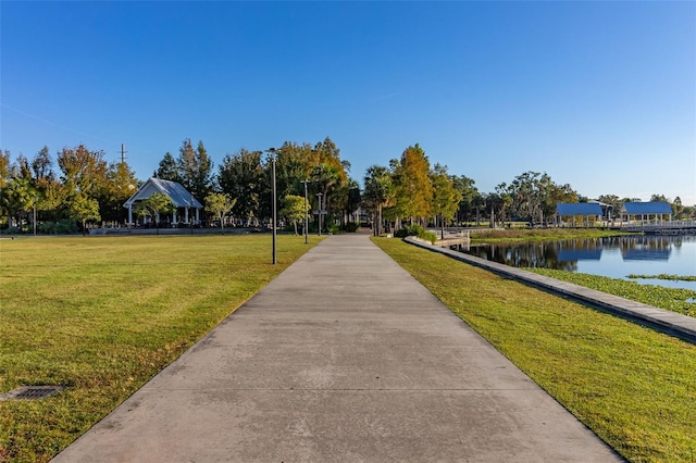 view of property's community featuring a yard and a water view