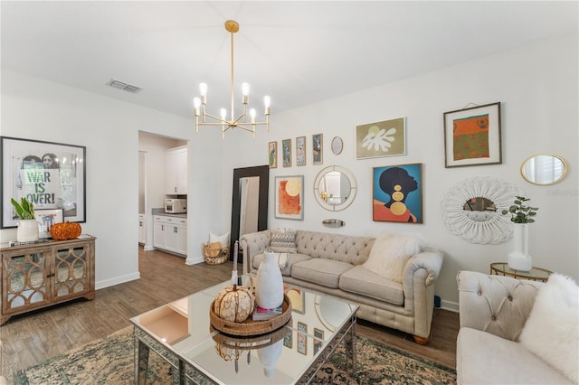 living room featuring an inviting chandelier and dark wood-type flooring