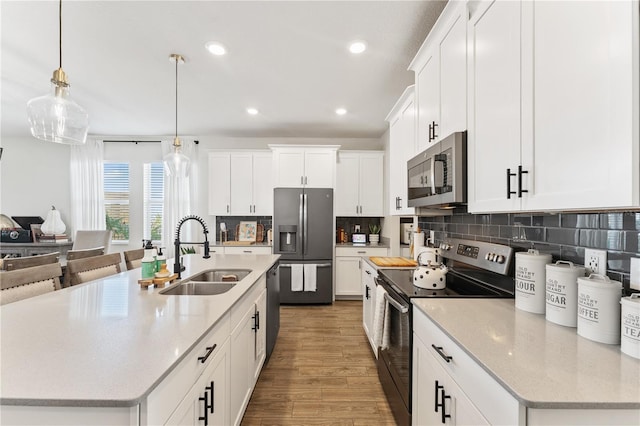 kitchen featuring white cabinetry, a kitchen island with sink, stainless steel appliances, and sink