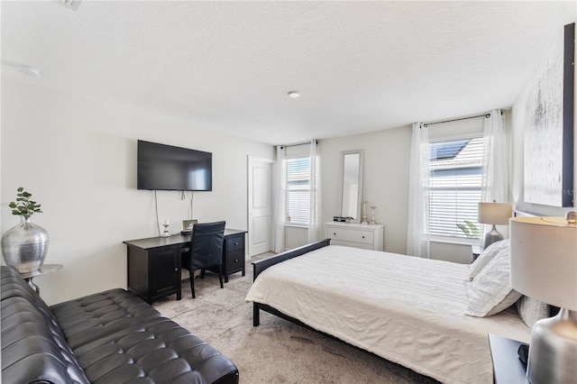 carpeted bedroom featuring a textured ceiling and multiple windows