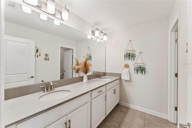 bathroom with vanity, a textured ceiling, and tile patterned flooring