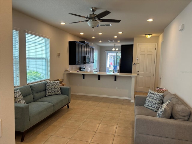 living room featuring light tile patterned flooring, plenty of natural light, and ceiling fan