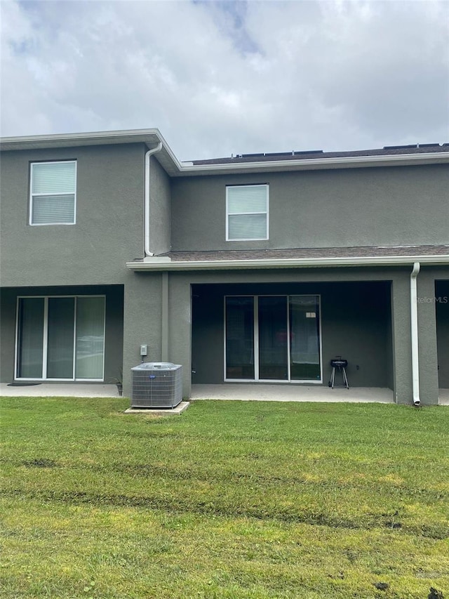 back of house with a yard, central AC unit, and a patio