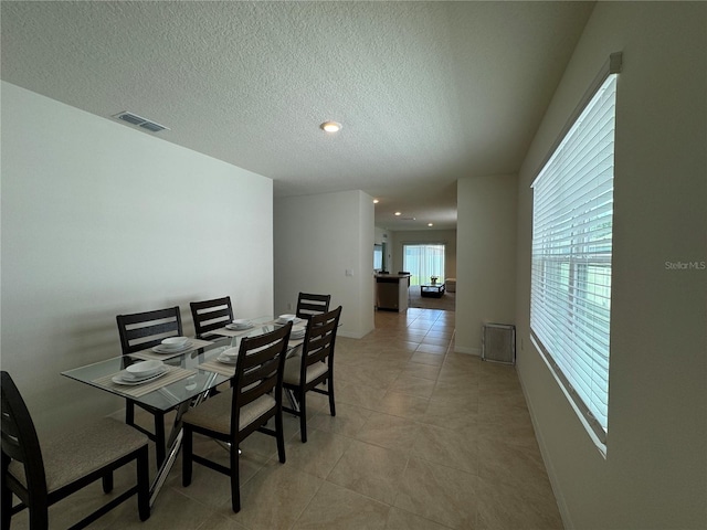 tiled dining area with a textured ceiling