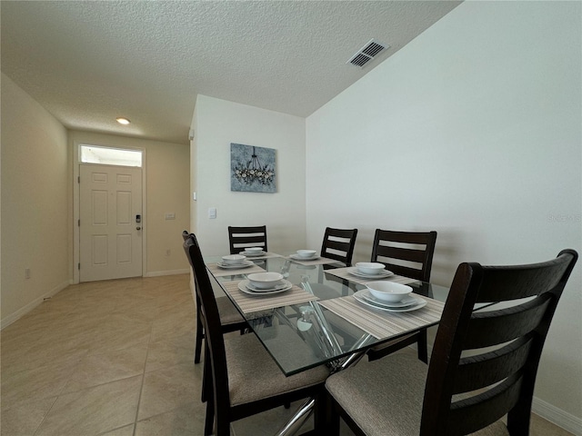 tiled dining area with a textured ceiling