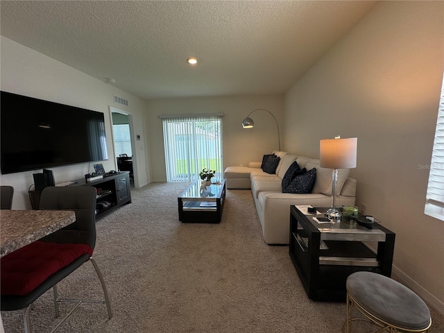 living room featuring light carpet and a textured ceiling