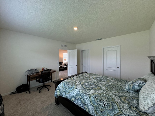 bedroom with a closet, a textured ceiling, and carpet flooring