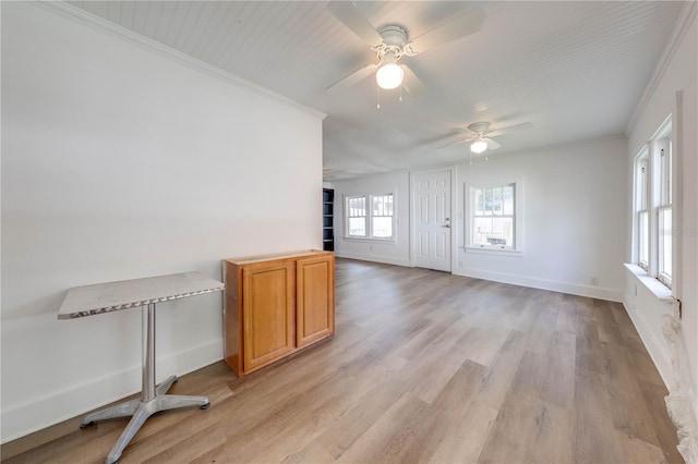 unfurnished room featuring ornamental molding, light wood-type flooring, and ceiling fan