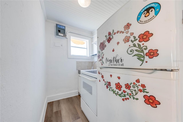 kitchen featuring white appliances, light hardwood / wood-style floors, and crown molding