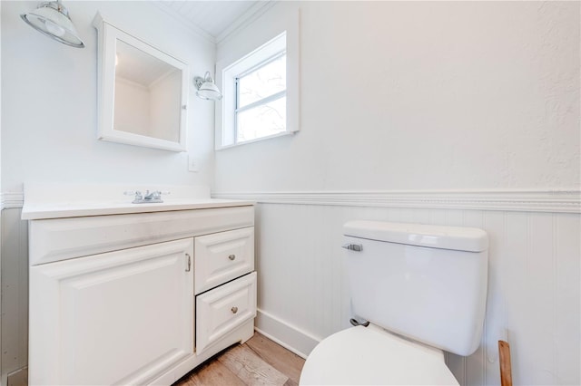 bathroom featuring vanity, toilet, crown molding, and hardwood / wood-style floors