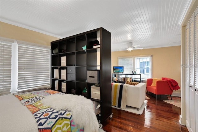 bedroom featuring a closet, crown molding, ceiling fan, and dark hardwood / wood-style flooring