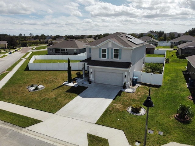 view of front of house with solar panels, a garage, and a front lawn