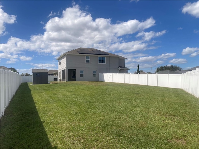 back of property with a storage shed and a lawn