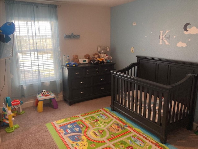 bedroom featuring light carpet and a nursery area