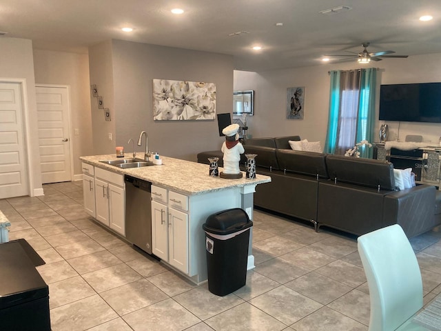 kitchen with ceiling fan, a kitchen island with sink, sink, dishwasher, and white cabinetry