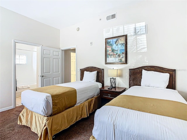 carpeted bedroom with connected bathroom and multiple windows