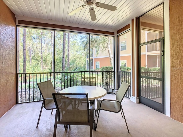 sunroom / solarium featuring a healthy amount of sunlight, wooden ceiling, and ceiling fan