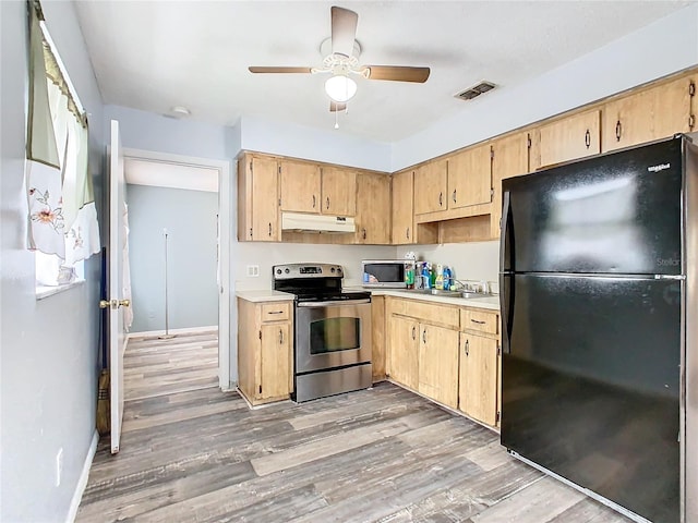 kitchen featuring appliances with stainless steel finishes, light brown cabinets, and wood-type flooring