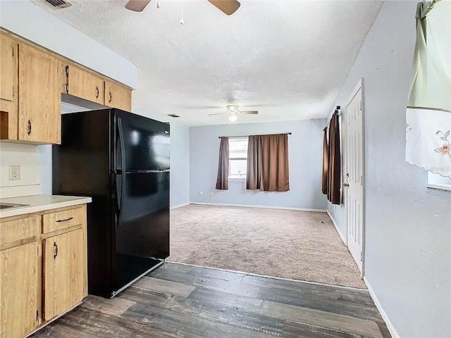 kitchen with ceiling fan, black refrigerator, and dark hardwood / wood-style flooring