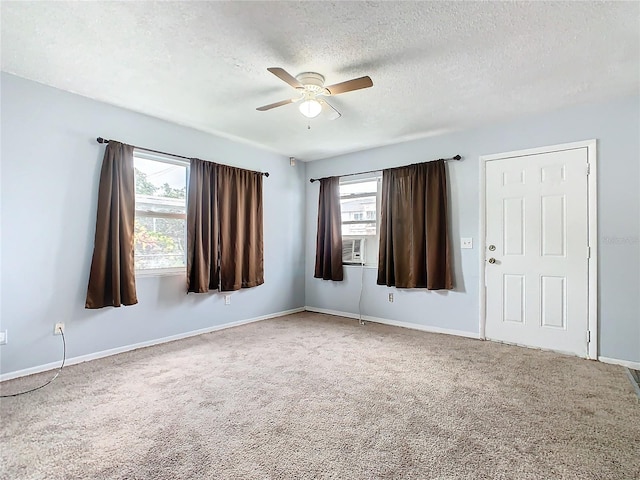 carpeted spare room featuring cooling unit, a textured ceiling, and ceiling fan